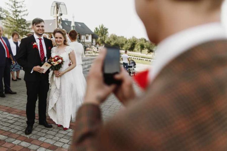 man-taking-photo-on-phone-of-luxury-happy-wedding-AZ.jpg